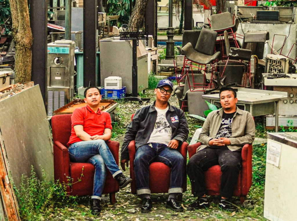 Otakotormedia - Pada perayaan 25 tahun Demajors, saya berkesempatan untuk berbincang dengan Gerry dan Gilang Fresandy, basis dari Dirty Ass, sebuah band asal Tangerang yang dikenal dengan gaya musik garage rock, punk, dan rock n roll penuh energi. Dalam wawancara eksklusif ini, mereka berbagi cerita mengenai perjalanan panjang mereka dalam bermusik, tantangan dalam membagi waktu antara pekerjaan, ngeband, dan kolektif Elang Terbang. Serta bagaimana mereka dapat bisa berkoneksi dengan scenester lain di kancah musik internasional. Dirty Ass, band yang beranggotakan Gerry Lainil Fauzi (Vokal dan gitar), Bayu Samudro (drum) dan Gilang Fresandy (bass) telah merilis beberapa album dan karya, termasuk EP, split album, dan kompilasi. Mereka dikenal sebagai band yang produktif dalam berkarya, dengan rilisan seperti vinyl ‘7 inch’ dan ‘12 inch’ yang sempat dirilis di US dan Belanda. Tahun 2023 mereka merilis Album 7" Setubuhi Dirimu Sendiri - Slovenly Recordings (US) dan 12" 4Way Split w/ HONG!, Fake Fun & Squeling Nipples (Netherland) - Fuckingtrash Records. Kemudian di tahun 2024 mereka merilis, Dirty Ass Live Albums (Digital on Bandcamp). Terakhir tahun 2025 Album 7" Manifes - Demajors Records (IN). Dalam percakapan ini, Gerry dan Gilang menjelaskan bagaimana mereka mengelola waktu untuk menjaga eksistensi band, meskipun masing-masing personel juga memiliki proyek lainnya. Mereka juga membahas mengenai pengaruh Elang Terbang kolektif terhadap karir mereka, yang memberi banyak kesempatan untuk berkolaborasi dengan band-band lain serta membangun jejaring yang lebih luas. Melalui cara ini, mereka mampu menjangkau pasar internasional, khususnya di negara-negara seperti Amerika Serikat dan Belanda. Berikut wawancara dengan Gerry, gitaris dan Gilang, basis Dirty Ass: A: Dirty Ass dikenal sebagai band yang cukup produktif di kalangan teman-teman dari Tangerang dan juga kolektif Elang Terbang. Gimana caranya bagi waktu, antara kerja, ngeband, dan kolektif? Gery: Yang jelas karena kita senang sih melakukan itu semua ya. Ya lu tahu kan istilahnya kayak lu lagi jalan di sebuah gunung dan lu terperosok di sebuah jurang yang dalam dan lu nggak bisa naik. Nah kita udah kayak gitu sebenarnya. Udah di posisi itu. Udah di posisi yang sulit untuk nggak main musik kayaknya ya. Jadi kayaknya itu doang yang bisa lu lakuin. Gilang: Basicnya karena udah senang main musik aja. Udah nyemplung. A: Kalian udah berapa album sih, empat ya? Hampir 10 rilisan ya? Gery: Pokoknya kalau album tiga, terus kalau sama EP sendiri dua. Sama ada beberapa EP dan split album. Iya kompilasi sama beberapa rilis single gitu. Tapi kalau berbicara album fisik mungkin nggak sampai 10 ya. Terakhir itu kita rilis (vinyl) '7 inch' sama '12 inch' di US sama di Belanda. Gilang: Nggak sampai sepuluh. Triway split, Fourway split. Beberapa kompilasi. A: Apa yang bikin Dirty Ass masuk radar teman-teman di luar negeri, khususnya kayak di US atau Belanda? Sementara banyak band-band di Indo yang agak kesulitan untuk menjangkau ke sana. Tips-nya mungkin? Gilang: Networking. Networking pasti. Ya bener. Nah kalau misal kayak lu sebatas kenalan di Facebook aja sebatas ngobrol-ngobrol gitu, mungkin nanti bisa meluas jaringannya. Itu kalau menurut gue sih nggak usah ragu-ragu untuk approach orang. Apalagi kayak mungkin let say dia punya record label atau dia di band yang musiknya sama kayak kita. Jadi kita bisa sharing-sharing gitu sih. Gery: Digging a rabbit hole. Iya, nebelin ya. Gue nebelin statement Gilang. Sebenarnya sama tuh kurang lebih. Terus memanfaatkan semua aset yang kita punya ya. Bandcamp itu kan memberikan kita akses untuk kita bisa komunikasi kan sama followers. Itu juga sering kita maksimalin. Jadi gue sering korespondensi sama banyak fans gue, katakan 'pendengar' aja ya, 'listener' kita di Bandcamp, terus di Facebook. Terus ya sama kayak layaknya band yang ber-kolektif dari band yang datang ke Indonesia melalui Tangerang gitu. Dari beberapa circle kita di luar Tangerang saling lempar-lempar dan segala macam, itu yang kita maintenance tuh sampai hari ini. Dan akhirnya membuat kita sampai di-notice sama banyak orang di luar negeri. Kayak gitu sih. A: Kalian kan terlibat di kolektif Elang Terbang, ada nggak pengaruhnya sama milestone-nya Dirty Ass? Gery: Waduh, itu jelas banget tuh, berpengaruh besar tuh ya. Justru itu, yang membentuk sebagaimana mental kita sekarang. Anjing.. Gilang: Itu krusial itu. Betul. Karena emang kita awal-awal sering banget main di Elang Terbang kolektif, dan kita menyambut band-band yang datang. Apalagi main pertama, jadi band pembuka kan. Itu karena nggak ada yang mau main pertama, cuma kita, Dirty Ass sih. Ya terus akhirnya menjalin komunikasi, menjalin koneksi juga dengan band yang lagi tour. Gerry: Iya jejaringnya sih. Eee, di Elang Terbang tuh kayak semacam rekreasi kita untuk bisa mengenal banyak orang ya. Terus bisa memperkenalkan musik kita secara sehat gitu. Misal gue secara personal aja, dari Elang Terbang tuh gue belajar akhirnya gue membentuk sebuah records (Roaches Records), label yang membantu teman-teman di Tangerang juga. Itu semua adalah tempat bermain. Roaches Records, tapi udah nggak ada sekarang, 2025. Itu label dari Dirty Ass, gue dan Bayu (drummer) yang bikin. Eee itu di momen-momen saat itu kita mau membubarkan Dirty Ass justru fun fact-nya. Tapi akhirnya malah merilis band dia yang lain, terus akhirnya keterusan. Itu jujur sungguh rumah yang menyenangkan. A: Masing-masing personel Dirty Ass punya banyak proyek. Gimana bagi waktu atau ada plan khusus? Gilang: Ya kalau kita sih sebenarnya fair-fair-an aja. Janji duluan mana yang kita buat. Kayak misalnya ada tawaran manggung, "Ya sorry nih kita nggak bisa. Gue udah ada main sama band sebelah." Atau misal minggu gue kerja, let say nggak bisa. Ya paling dikomunikasikan aja. Kita selalu punya solusinya kok. Either nyari pemain pengganti atau gimana. Gery: Komunikasi sih sebenarnya. Ya kan, menurut gue nih setiap permasalahan manusia itu dari bentuk komunikasinya. Ajeeng.. Ya kayak gitu sih. A: Apakah proyek di band lain jadi alter ego kalian selain Dirty Ass? Misal Gerry sama HONG! juga kencang merilis karya. Itu gimana? Gilang: Kalau gue kayaknya semua band itu alter ego gue. Yang main ego-nya adalah seorang karyawan. Hahaha. Kalau lu gimana Ger? Gery: Hahaha. Ya sebenarnya sama, itu tadi nggak ada yang ngeganggu satu sama lain selama memang lu udah tahu dari awal konsekuensinya. Gue sama Gilang tuh ada tiga, selain Dirty Ass, ada The Regards, dan Roten. Itu tiga-tiganya berbeda tuh, yang mana musiknya berbeda. Karena memang punya komitmen dan komunikasi yang bagus ya kita bisa jalan kayak gitu. Walaupun ditengah kesibukan kita lagi kerja, atau hal lainnya. Gilang: Tapi kalau gue pribadi nggak bisa statement kalau "Oh gue nih Dirty Ass aja. Atau gue The Regards aja." Pokoknya semua band yang ada gue-nya ya gue. Emang gue suka main musik aja. Nggak pengen self-proclaim. Anjayyy.. A: Tips and trick biar bisa rutin tour, bahkan bisa sampai ke luar negeri? Gilang: Emang setahun sekali rutin ya Ger? Gery: Rutin sih kayaknya. Gilang: Sebenarnya kita tour itu biasanya kalau ada rilisan baru ya. Misalnya ada rilisan baru, berarti rekaman nih. Oh rekaman nanti akan rilis dong. Nanti setelah rilis kita tour kali ya. Itu kayak udah di planning aja sih. Yang pasti balik lagi ke komunikasi, terus gue nyiapin cuti juga. Gery: Sama sih. Kalau dibilang rajin, eee, tahun kemarin berapa, 10 kota, 2 negara. Tapi bisa begitu karena memang di bisa-bisain ya. A: Secara finansial gimana untuk tour? Gery: Secara finansial, band ini sudah bisa memberikan finansial sendiri untuk berbagai macam kegiatan untuk band ini. Gilang: Alhamdulillah udah bisa motek-motek dari finansial band ini sih. Gery: Udah bisa me-manage bagaimana band ini bisa menghidupi band itu sendiri. Jadi kita bisa dibilang sudah tidak punya beban untuk membiayai si band sebenarnya kayak gitu. Walaupun itu memang butuh proses untuk di titik kayak gitu. Proses yang cukup lama sih. Sebenarnya bisa asal lu mau konsisten aja sih. Ya kayak misalkan gini, gue rilis Manifes sama Demajors dalam bentuk (vinyl) '7 inch' gitu ya, yang nanti tahun ini akan rilis. Kita udah nge-set, kita akan melakukan tour di beberapa kota. Tapi kita akan membuat waktu-waktu yang memungkinkan bisa kasih masuk agenda band. Nggak dipaksain. Gilang: Disesuaikan aja sama jadwal masing-masing. Tetap fleksibel. A: Tahun ini Dirty Ass mau ngapain lagi? Gery: Ya itu tadi, album Manifes rilis vinyl '7 inch' oleh Demajors. Langsung tour. Kayaknya lokal dulu. Ya tapi kalau ada rejeki boleh. Siapa tahu ke Afrika. Hahaha. Gilang: Ke Kenya, main di Kenya. Gery: Hahaha. Ya tapi kemanapun, untuk sementara waktu kita sudah punya plan-nya. Yang jelas kita akan tour. Daerah mananya mungkin belum bisa di-spill. Karena masih nunggu waktu kapan ini mau rilis sih, kayak gitu. Gilang: Mungkin kalau kontak-kontak kita boleh lah. You Call, I Show.